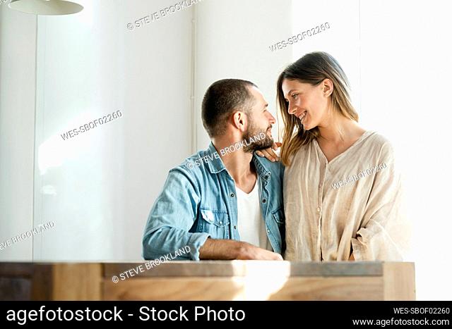 Affectionate couple in love relaxing at home and sitting at table