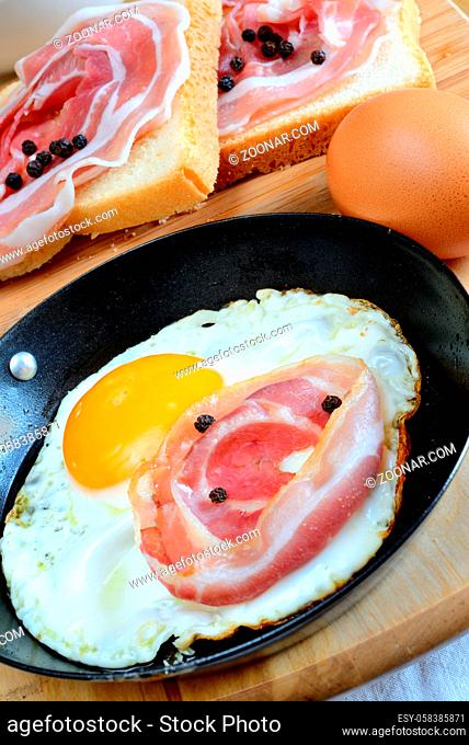 fried egg with bacon and toasted bread