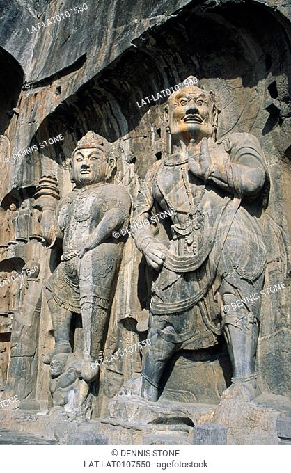 Limestone cliff recesses near Luohang. In Yi River gorge. Fengzian Si temple. Two large statues. Rock carving