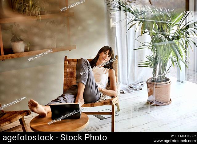 Woman resting while sitting on chair at home