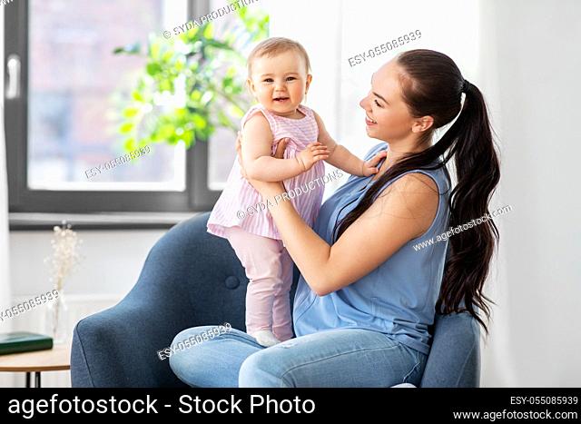 happy mother with little baby daughter at home