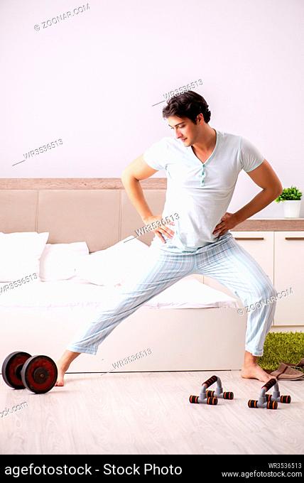 Young man doing morning routine in bedroom