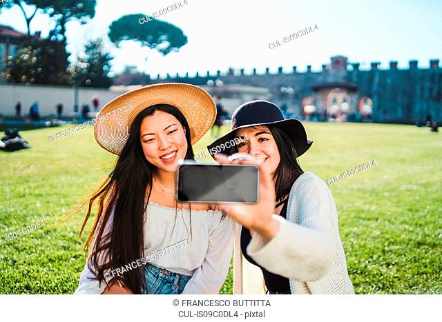 Friends taking selfie on field, Pisa, Toscana, Italy