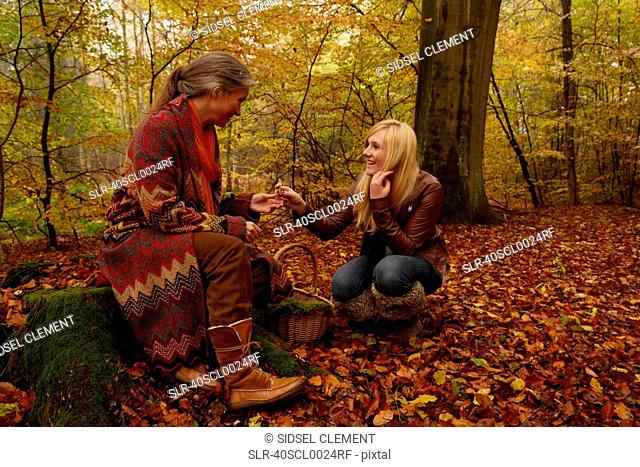 Mother and daughter talking in forest