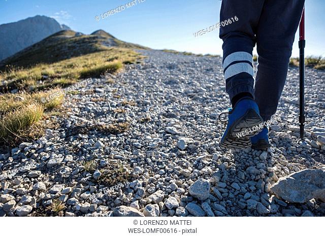 Italy, Abruzzo, Gran Sasso e Monti della Laga National Park, legs of boy on hiking trail