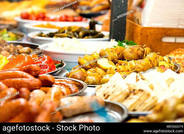 Food street festive of traditional asian cuisine with vegetables, meat and sausage on market