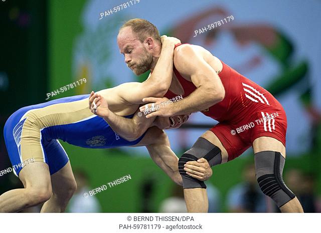 Germany's Marcel Ewald (red) competes with Viktor Lebedev (blue) of Russia in the wrestling Men's 57kg Freestyle Finale at the Baku 2015 European Games in the...
