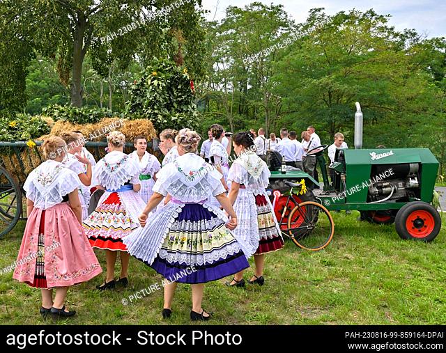 12 August 2023, Brandenburg, Heinersbrück: Young women in Sorbian-Wendish festive costumes wait for the beginning of the village and harvest festival