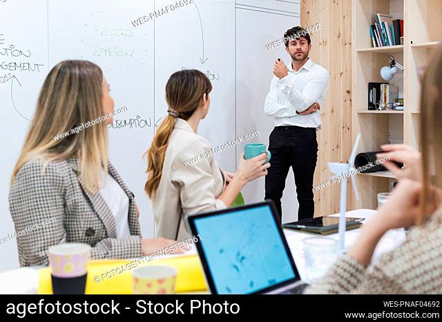 Businessman giving a presentation to colleagues in office