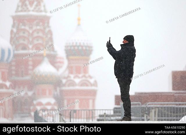 RUSSIA, MOSCOW - DECEMBER 10, 2023: A man takes pictures in Red Square with St Basil's Cathedral in the background. Sofya Sandurskaya/TASS