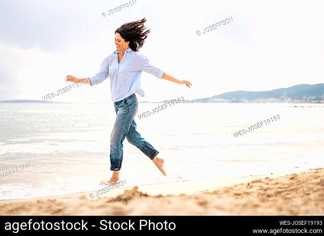 Playful woman enjoying beach holiday at sunny day