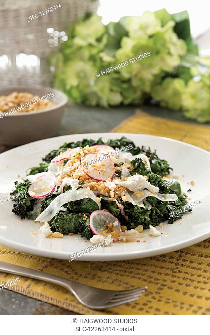 Grilled kale salad with sliced radish and pine nuts garnish