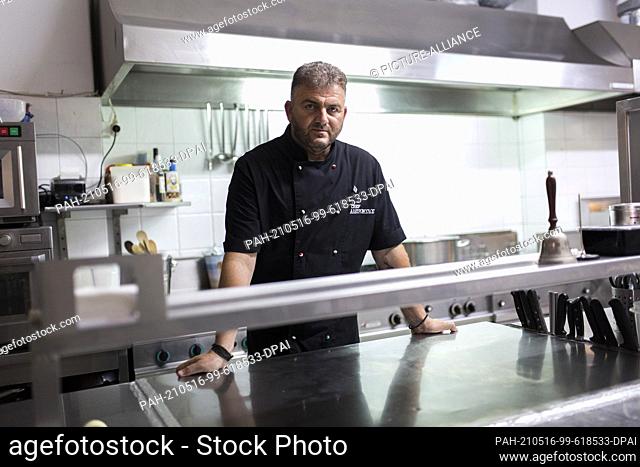 13 May 2021, Greece, Milos: Papikinos Vasilis, a 46-year-old chef, takes photos in the kitchen of his restaurant Alevromilos on the island of Milos