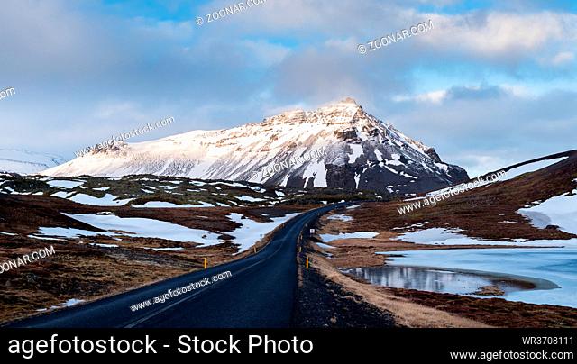 Typical Icelandic snowy nature mountain landscape and empty road near Arnarstapi area in Snaefellsnes peninsula in Iceland