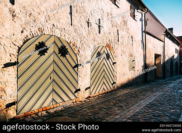 Riga, Latvia. Facade Of Ancient Medieval Building With Big Closed Gate On Cobbled Torna Street In Old Town. Cultural Monument, Architectural Historical Heritage