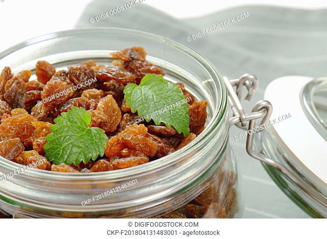 jar of sweet raisins on grey place mat - close up