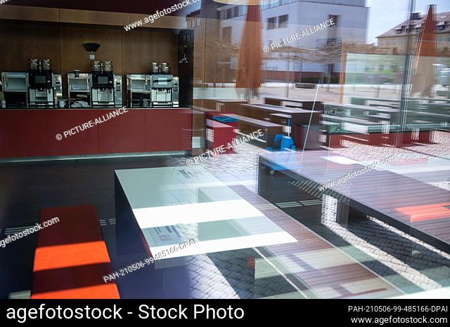 PRODUCTION - 28 April 2021, Hessen, Fulda: The outside of the canteen at Fulda University of Applied Sciences is reflected in its glass