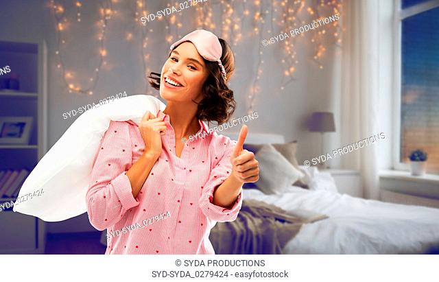 woman with pillow in pajama showing thumbs up