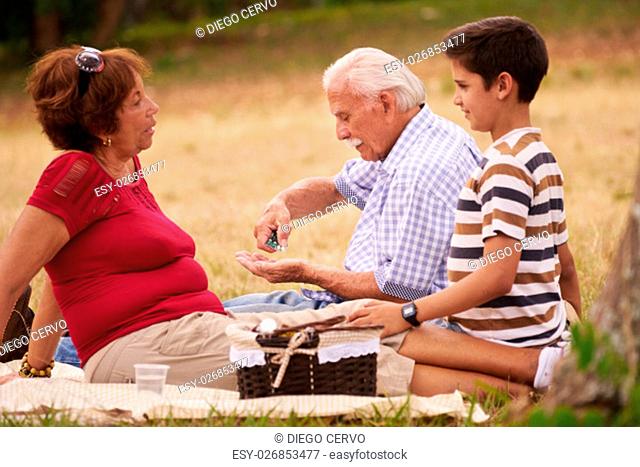 Old people, senior couple, elderly man and woman in park. Sick grandpa taking prescription drugs, medicine, pills for heart care, illness, disease
