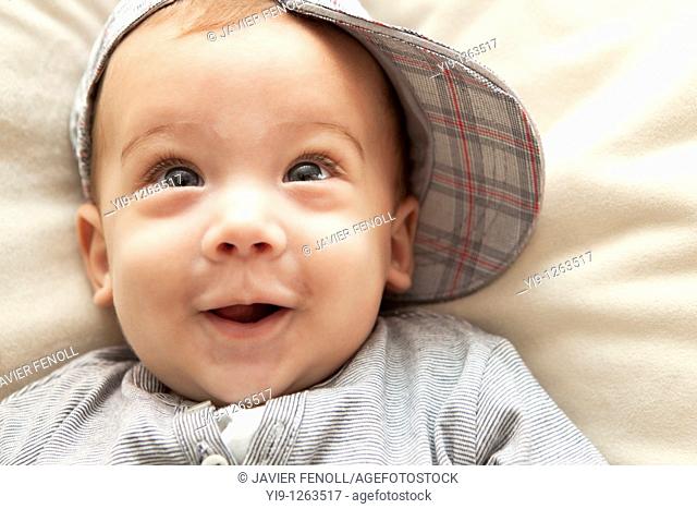 Studio shot of baby boy wearing hat and smiling