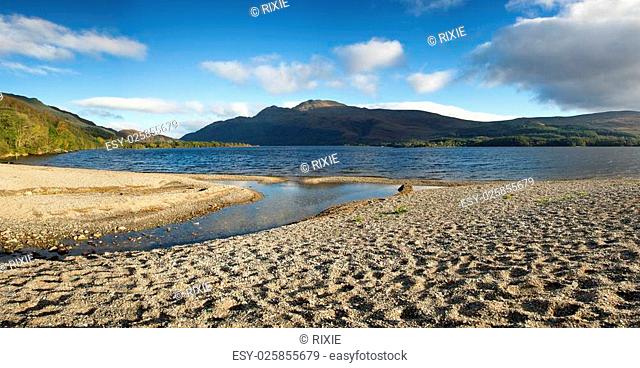 Panorama of a small shingle beach at the edge of Loch Lomond, Scotland