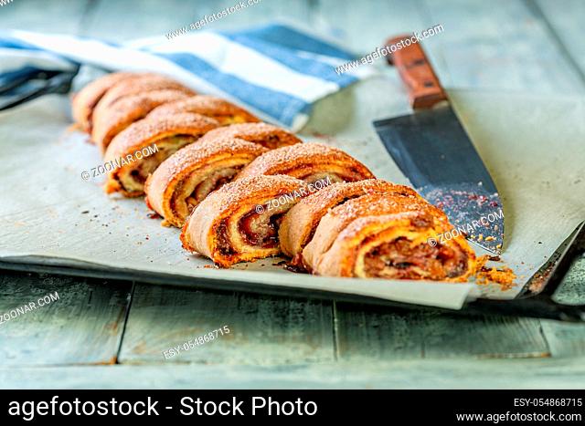 Rugelach with jam, walnuts, raisins, sprinkled with sugar and cinnamon and sliced, selective focus