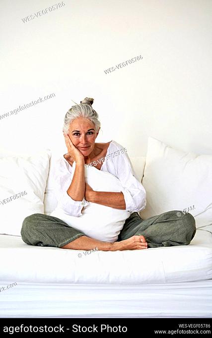 Smiling woman sitting on couch at home