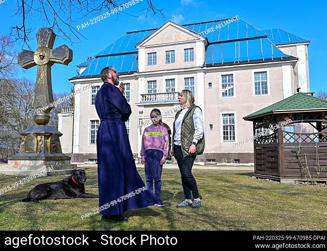25 March 2022, Brandenburg, Götschendorf: Abbot Daniil Irbits of the St. George Monastery of the Russian Orthodox Church talks with Irina and her nine-year-old...