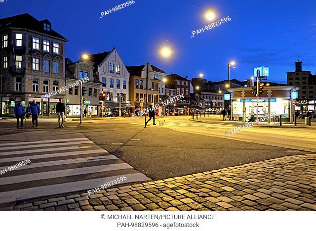 Illuminated pavement with a pedestrian crossing and traffic lights on the place Torget in the city of Bergen, 28 February 2017 | usage worldwide