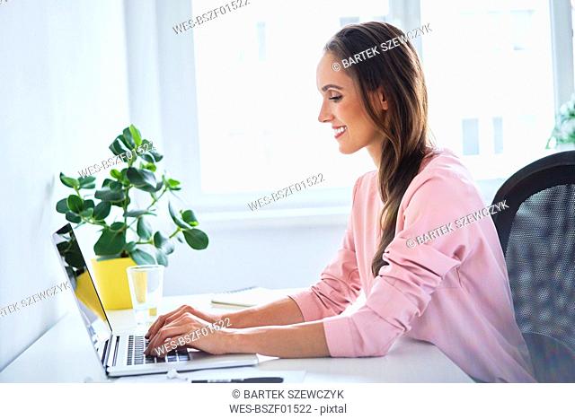 Young woman working on laptop in home office