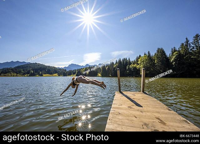 Young woman taking a header into a lake, Geroldsee, Mittenwald, Karwendel, Bavaria, Germany, Europe