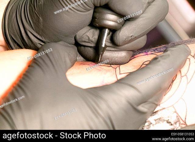 Antwerp, Belgium august 2017, A male tattoo artist making tattoo inside ink studio on blond woman