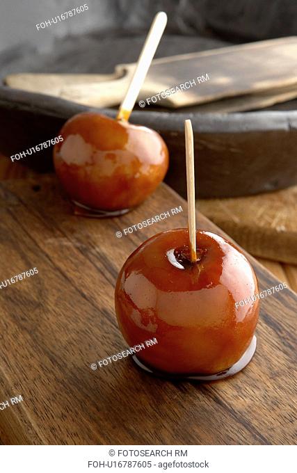 Toffee apples on wooden chopping board
