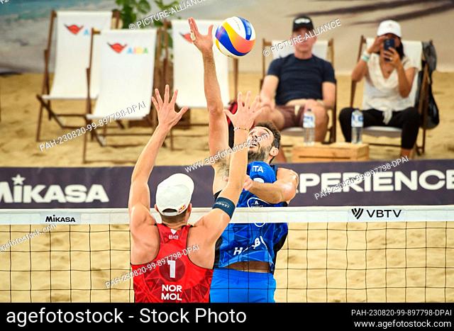 20 August 2023, Hamburg: Volleyball/Beach: Beach Pro Tour, Semifinal, Norway - Italy. Italy's Paolo Nicolai (r) plays the ball over the net against Norway's...