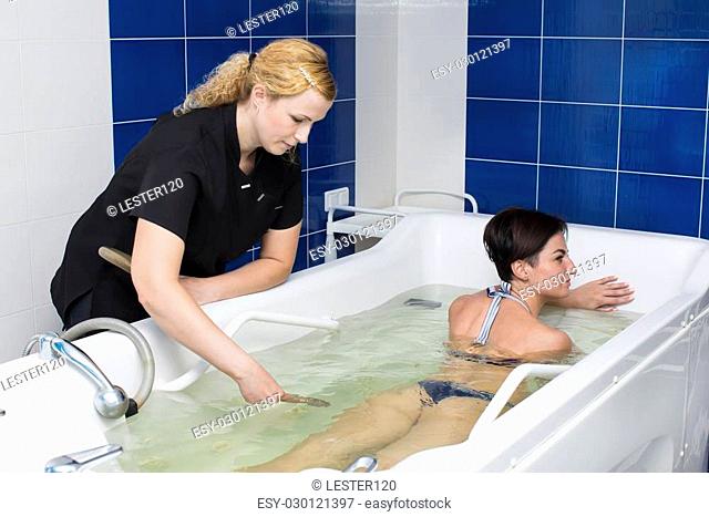doctor makes a woman a massage at hydrobath