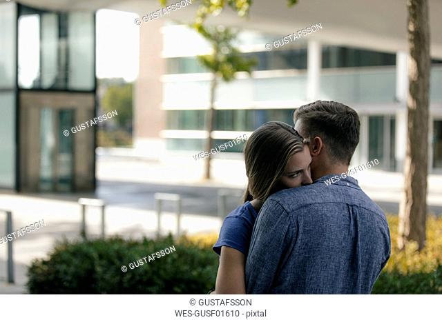 Netherlands, Maastricht, affectionate young couple hugging in the city