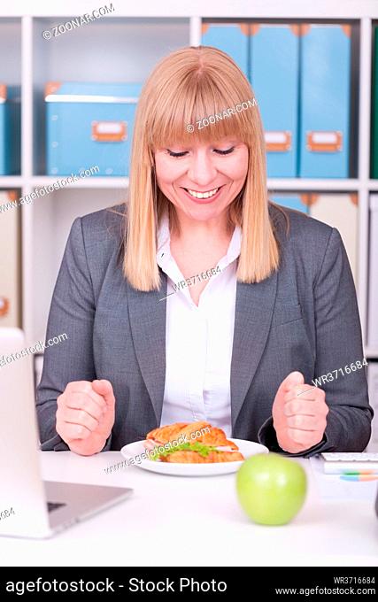 Woman at the office having lunch. Concept for healty or unhealthy food at work