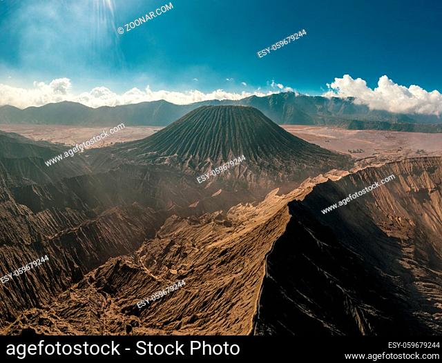 Cinematic shot aerial view of Mount Bromo crater edge with active volcano smoke in East Java, Indonesia