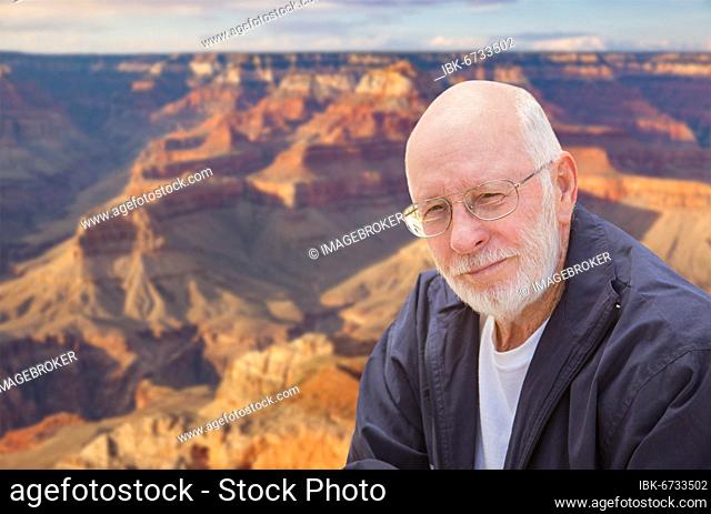 Happy senior man posing on the edge of the grand canyon