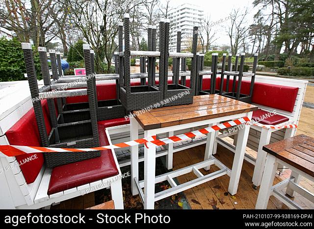 06 January 2021, Schleswig-Holstein, Timmendorfer Strand: Assembled tables and chairs stand in front of a food court on the Promenade during the second Corona...