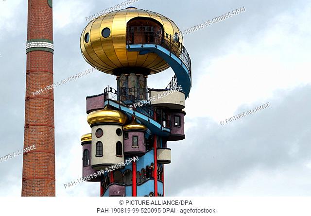 19 August 2019, Bavaria, Abensberg: The 35 metre high Hundertwasser Tower stands next to a chimney of the Kuchelbauer brewery