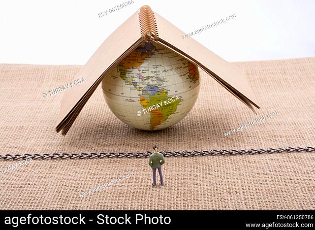 Man figurine and Globe on canvas with a chain in the middle
