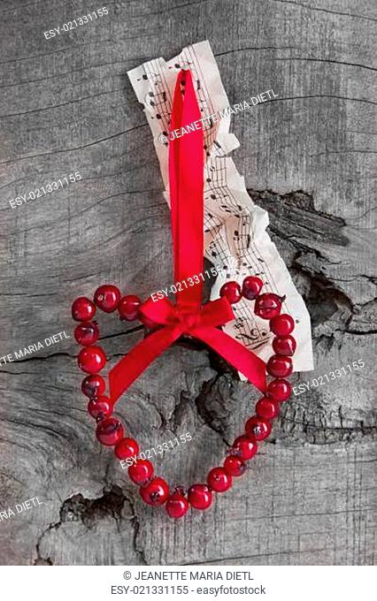 Top view of music sheet and rosehip heart for christmas decoration natural