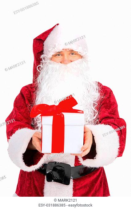 Kind Santa Claus in red costume giving present. While looking at camera and standing isolated over white background