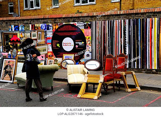 England, London, Notting Hill. Furniture and picture frames for sale in the street in front of Portobello ReCollection, a wall decorated as classic vinyl record...