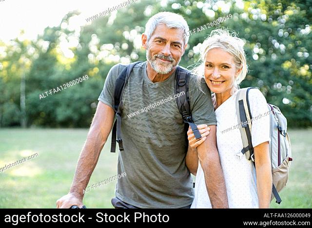 Portrait of smiling mature couple standing in forest