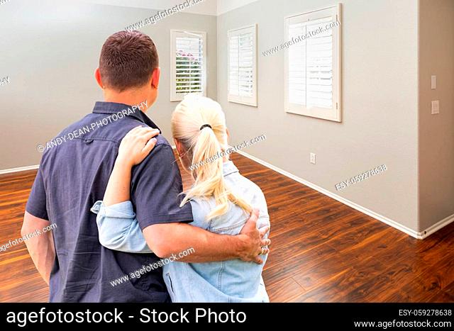 Young Couple Facing Empty Room of New House