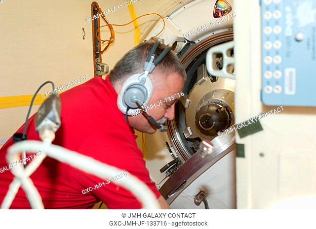Russian cosmonaut Fyodor Yurchikhin, Expedition 37 commander, closes the hatch between the Soyuz TMA-08M spacecraft and the International Space Station's Poisk...