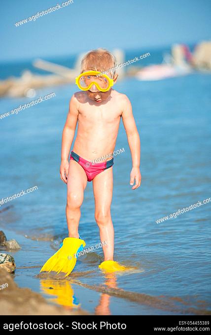 Little boy with snorkel by the sea. Cute little kid wearing mask and flippers for diving at sand tropical beach. Ocean coast
