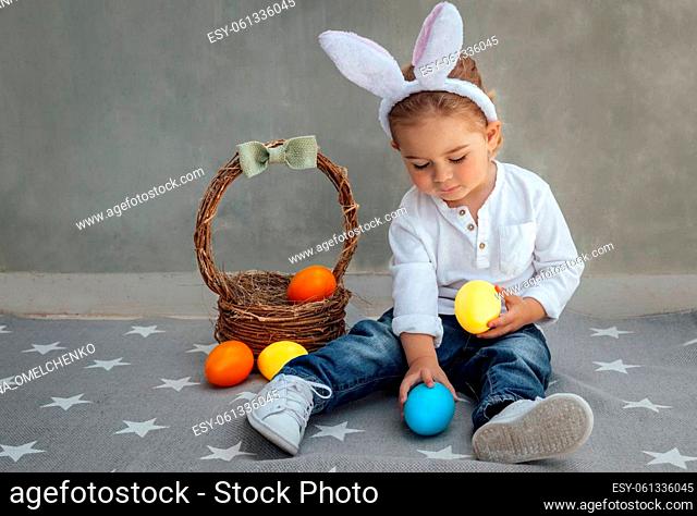 Cute Little Boy Dressed as a Bunny Playing with Decorations. Kid with Colorful Easter Eggs. Happy Easter. Spring Christian Holiday